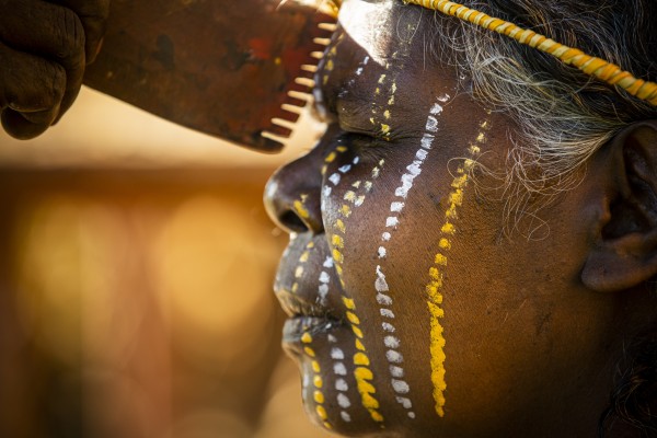 Elderly Aboriginal woman receiving traditional face painting