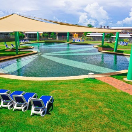 Pool, grassy area and lounge chairs