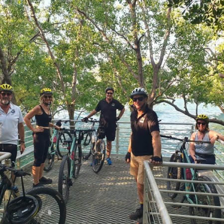 Group of people riding bikes on mangrove boardwalk 