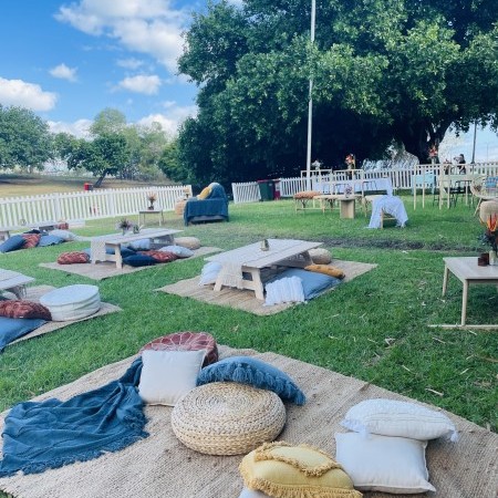 Outdoor event with mats and cushions on the grass