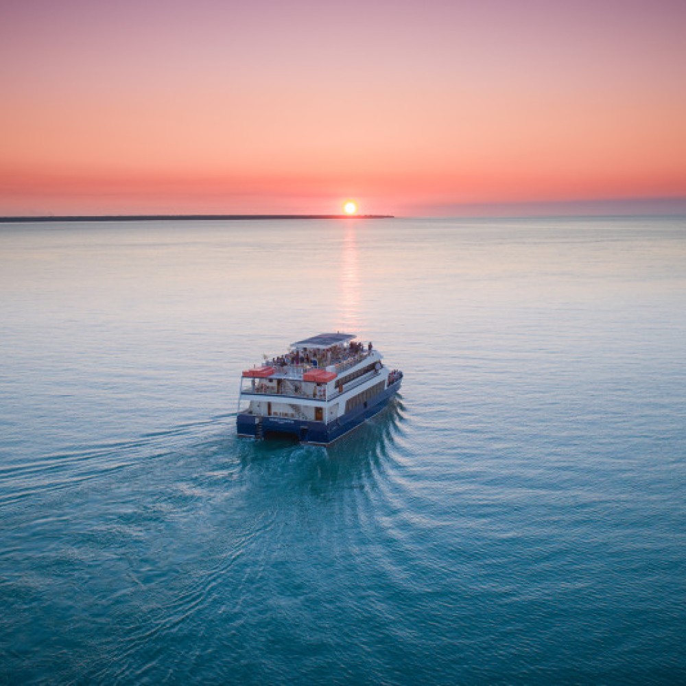 Ariel view of boat on the ocean at sunset 