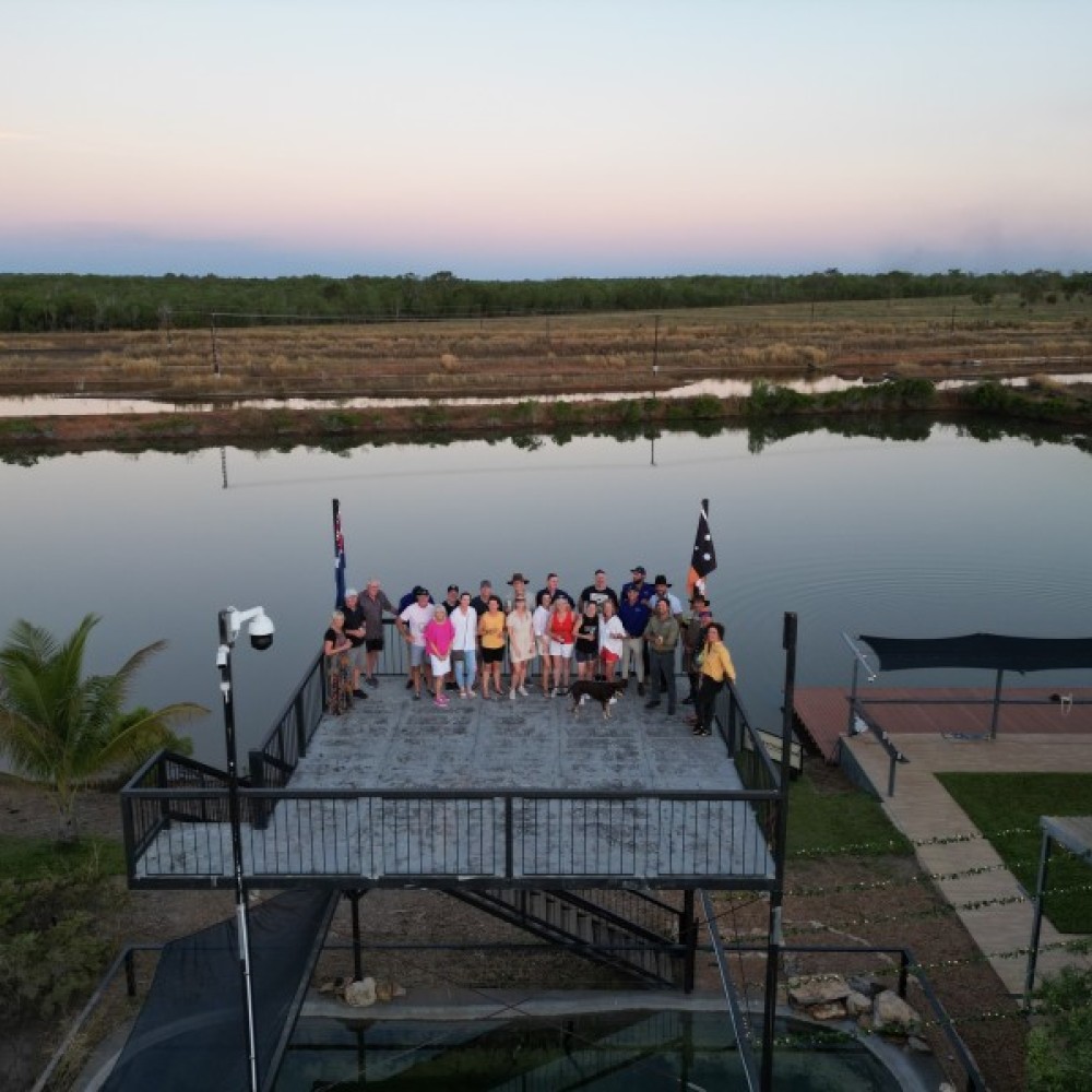 Group of people standing on balcony with body of water in background 