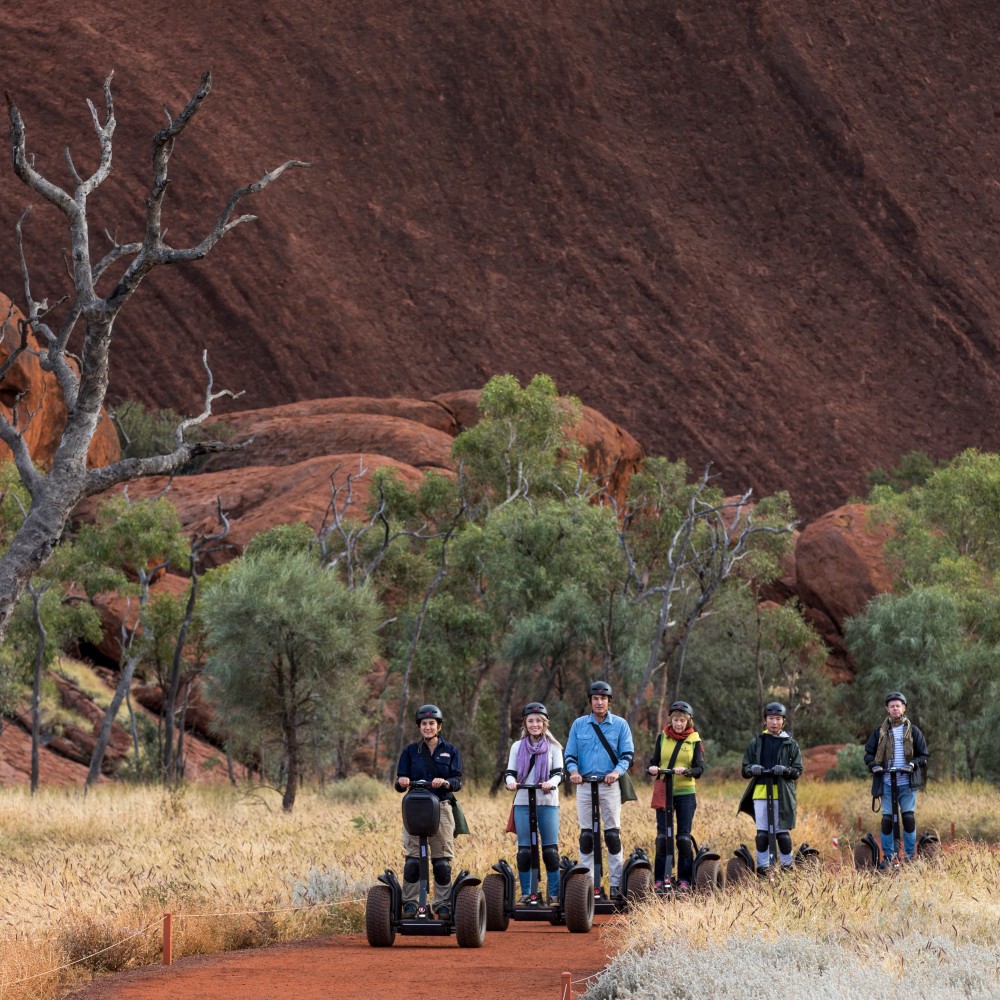 People riding Segways around base of Uluru